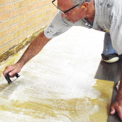 Brian Newman replaces the flooring in the music room at Nance Elementary. CDN | Emily Stephens Schools conduct
