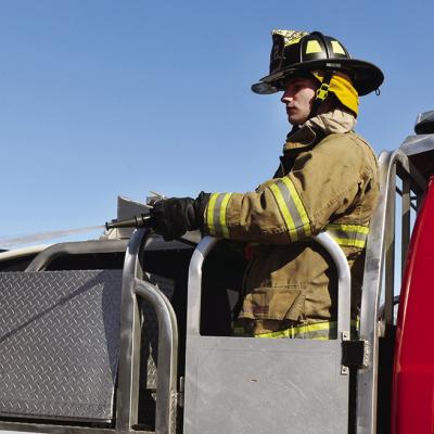 Firefighter Bobby Winans uses the firehose on the back of a truck to put out a small brush fire near the Riverside Golf Course. CDN | Caleb Blanchard Super soaker