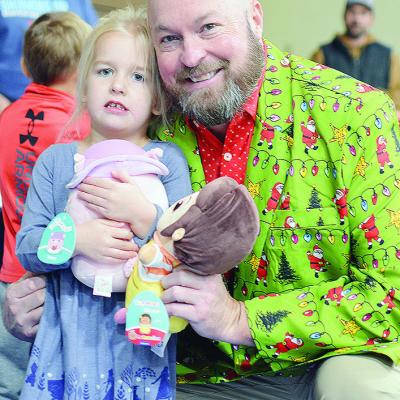 Scarlett Thomas, left, and Arapaho-Butler Public Schools Supt. Jay Edelen stand together after picking toys to take home from the Arapaho-Butler and Devon Energy Toy Express. CDN | Micah Ashcraft