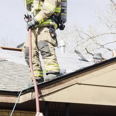 Clinton firefighter Bobby Winans, top, takes the hose from Interim Chief Mark Switzer, as they inspect a potential electrical fire Tuesday afternoon at 1725 W. Modelle Ave. CDN | Sam Goodwyn