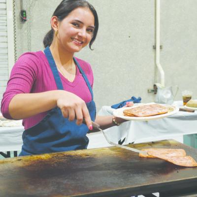 Clinton High School Key Club President Idalia Pelayo serves up some ham during the Kiwanis Pancake Day at the Frisco Center. CDN | Micah Ashcraft