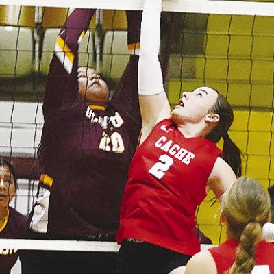 Clinton’s Aracelie Chavez, left, goes up to block a Cache player during the Lady Reds’ match against the Lady Bulldogs at the Tornado Dome. CDN | Sam Goodwyn