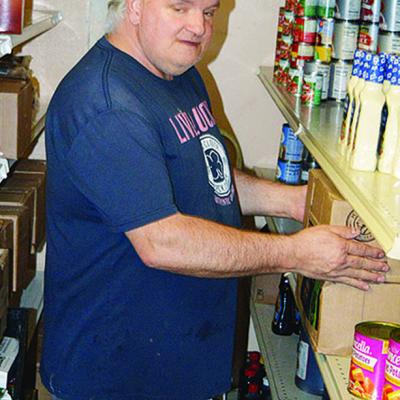 Mission House volunteer Mark Rice checks the food pantry at the facility. CDN | Michael Maresh Mission House volunteer Mark Rice checks the food pantry at the facility. CDN | Michael Maresh