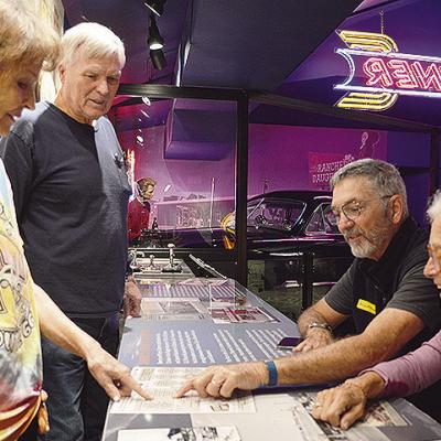 Oklahoma Route 66 Museum Director Pat Smith, left, and Virgil Smith show Stuart and Bevan Rogel from St. Petersburg, Fla., the price of some of the menu items from yesteryear at the museum’s diner exhibit area. CDN | Micah Ashcraft