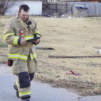 Clinton Firefighter Jacob Hoffman records evidence of damage while at the scene of three fallen utility poles Monday afternoon near the 900 block of N. 17th Street. CDN | Micah Ashcraft