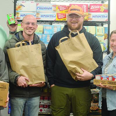 Edge Church members, front left, Tobi Green, Dane Krause, Stetson Green, Ashley Freelove; back, Hal Penner, and Kevin Leedy get bags of food ready to be given away for the Edge Church Grocery Giveaway set to start at 8 a.m. Sunday. CDN | Micah Ashcraft