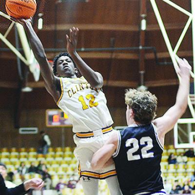 Clinton’s Atticus Thompson flies through the air for the layup during the Reds’ game against Bethany last year in the Tornado Dome. CDN | Sam Goodwyn