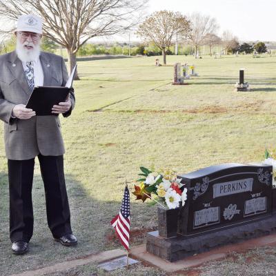 Mike Perkins talks about his parents, Bill and Mickie Perkins, next to their stone Monday night during the cemetery tour at Clinton Cemetery. CDN | Staff Photo