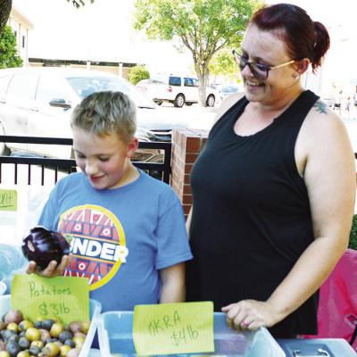 Hunter, left, and Ashley Sullivan view the different fresh produce available at the Clinton Farmers Market. CDN | Courtesy photo Farmers Market gearing up