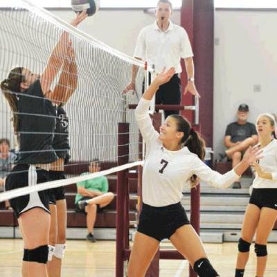 CDN | Collin Wieder Clinton middle hitter Hailey Ford, No. 7, tips the ball over Corn Bible Academy middle Abigayle Reimer's hand, while teammate Courtney Heerwald, right, watches the play. Article Image Alt Text