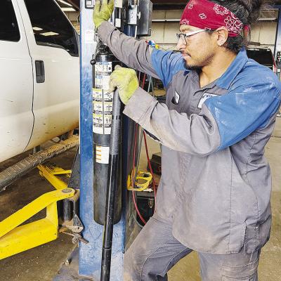 Roger Silva lifts a truck while at work at McKinsey Ford. CDN | Shiann Dawson