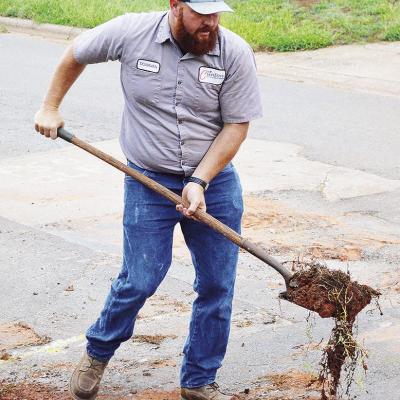 Donavan Phipps shovels debris away after clearing asphalt from a pipe under the road near the 1800 block of Opal Avenue. CDN | Micah Ashcraft Donavan Phipps shovels debris away after clearing asphalt from a pipe under the road near the 1800 block of Opal Avenue. CDN | Micah Ashcraft