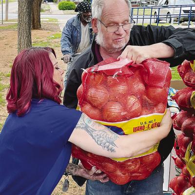 From left, Melissa Dquasie takes a large bag of onions from Tommy Caviness as the Mission House Tuesday morning unloaded a food truck for the community. CDN | Michael Maresh From left, Melissa Dquasie takes a large bag of onions from Tommy Caviness as the Mission House Tuesday morning unloaded a food truck for the community. CDN | Michael Maresh