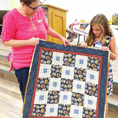 Lori Veazey, left, and Harper Nicholson, show the Cowboy Baby quilt they worked on together. CDN | Kelcie Hartley-Wolfe Quilting creates fellowship