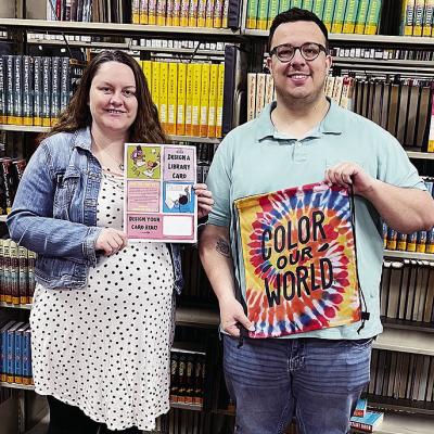 Western Plains Library System Director of Marketing and Outreach Micaela Marquez, left, and Conner Kirk, director of customer experience, show some of the activities WPLS will be putting on as part of National Library Week. CDN | Michael Maresh Western Plains Library System Director of Marketing and Outreach Micaela Marquez, left, and Conner Kirk, director of customer experience, show some of the activities WPLS will be putting on as part of National Library Week. CDN | Michael Maresh