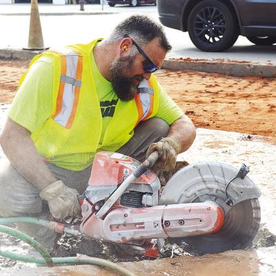 Blake Allen cuts out chucks of concrete from a sidewalk area Tuesday morning, just off of Gary Boulevard. CDN | Micah Ashcraft Blake Allen cuts out chucks of concrete from a sidewalk area Tuesday morning, just off of Gary Boulevard. CDN | Micah Ashcraft