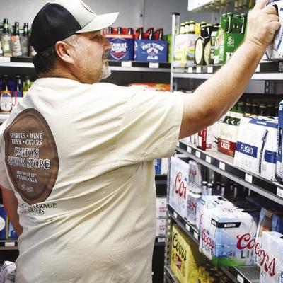 Marty Wandrie shelves products at Clinton Liquor Store located at 1018 S. 10th. CDN | Caleb Blanchard Wandrie keeps family’s ‘spirit’ going with his liquor store