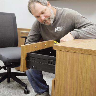 Dustin Sweatt finishes putting together an office desk into one of the rooms of the nearly completed site of the new Clinton Middle School building Thursday afternoon. CDN | Micah Ashcraft