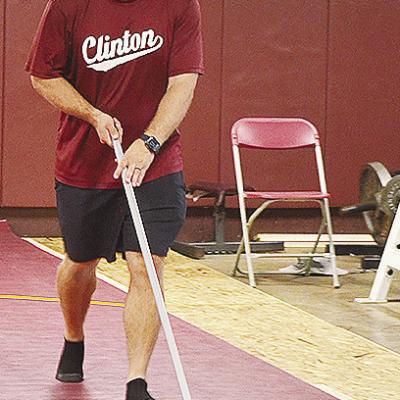 New Clinton High School wrestling coach Rhett Blundell sweeps the mats in the high school wrestling room Monday. CDN | Sam Goodwyn