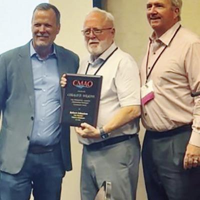 Oklahoma Municipal Management Services Executive Director Steve Whitlock, left, Clinton City Manager Robert Johnston, and past President of the City Management Association of Oklahoma Brooks Mitchell stand together after presenting Johnston with the 2025 