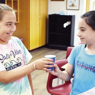 Paeton Eaton, left, and Victoria Weil share a snack they made at Summer Playground. CDN | Emily Stephens Sharing a tasty snack