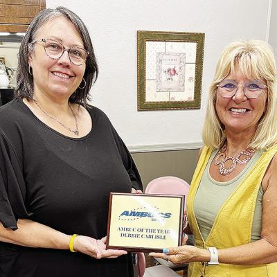 Misty Crider, left, presents Debbie Carlisle with a plaque after she was recognized for the AMBUC of the Year Award. CDN | Courtesy photo
