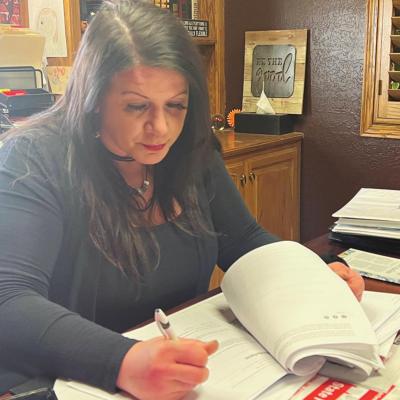 Stephenie Collins looks over insurance paperwork for one of her clients. CDN | Emily Stephens Collins enjoys getting to help her customers