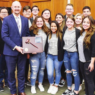 In the photograph at left, front row from left, are CHS teacher Ashley Kelley, Chelsea Nickel, Oklahoma Bar Association High School Mock Trial Program committee member Nathan Richter, Cara Herrera, Jolie Nguyen, Shelbi Goossen and Alexa Guzman Sanchez; an CHS team earns 4th in state