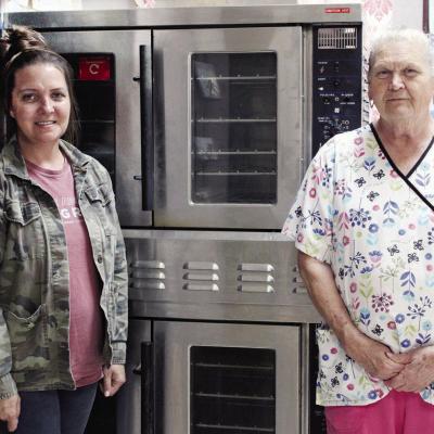 Mission House Director Jennifer Lee, left, and Sally James showcase the newly donated commercial oven from Southwest Elementary. CDN | Elisha Rangel Mission House closes for renovation