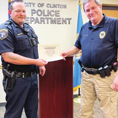 Officer Adam Hopper, left, receives his Lifesaving Award from Clinton Police Chief Paul Rinkel. CDN | Nydia Campbell Officer is honored for saving life