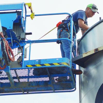 Brad Phillips lifts himself up on a crane to start the deconstruction of equipment Wednesday morning in the back lot of the Circuit Engineering Dist. No. 7 plant. CDN | Micah Ashcraft
